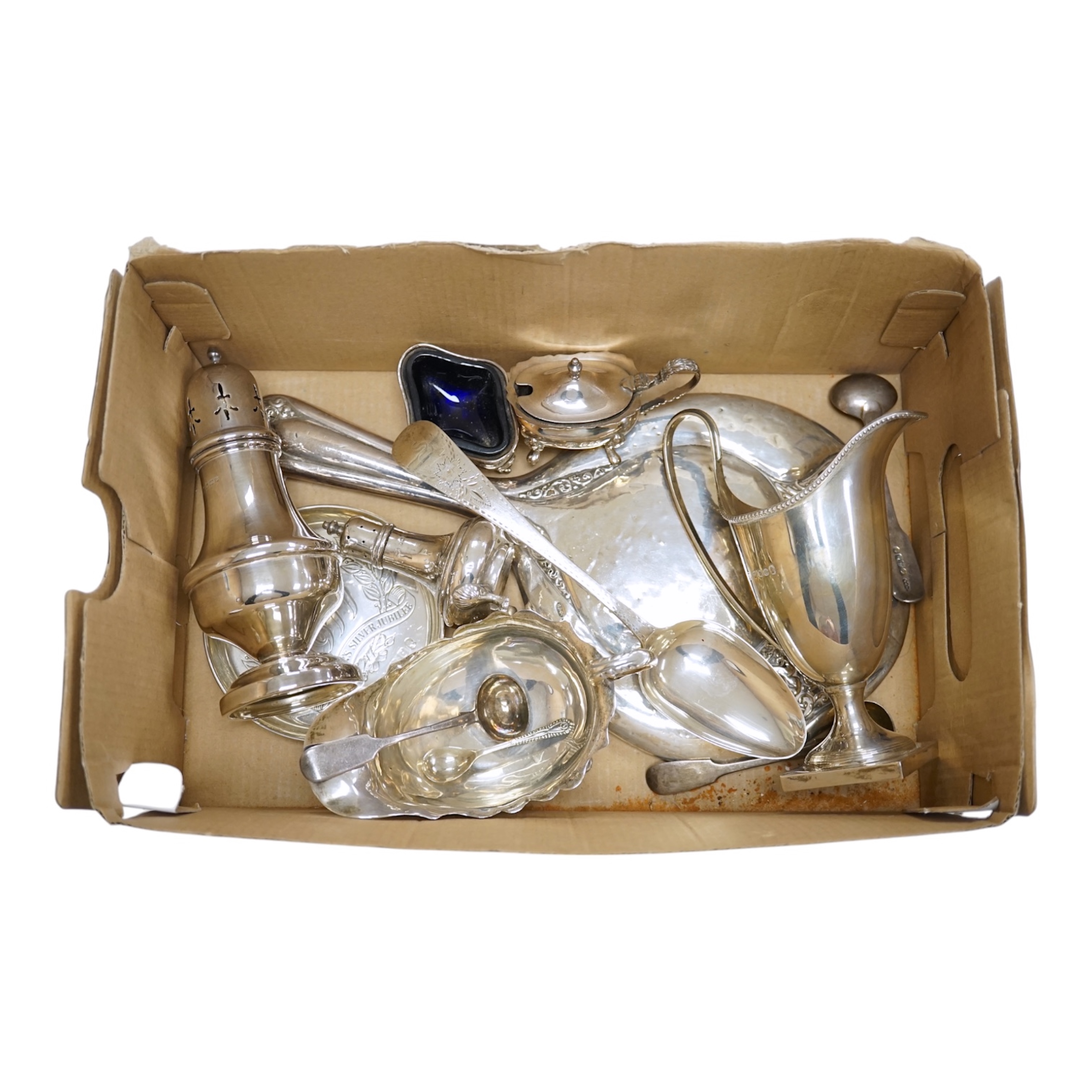 Assorted small silver including a 1970's cream jug, 15.6cm, a sauceboat, a sugar caster, three condiments, a small commemorative dish, a George III table spoon, hand mirror and four condiment spoons, 18.6oz. Condition -